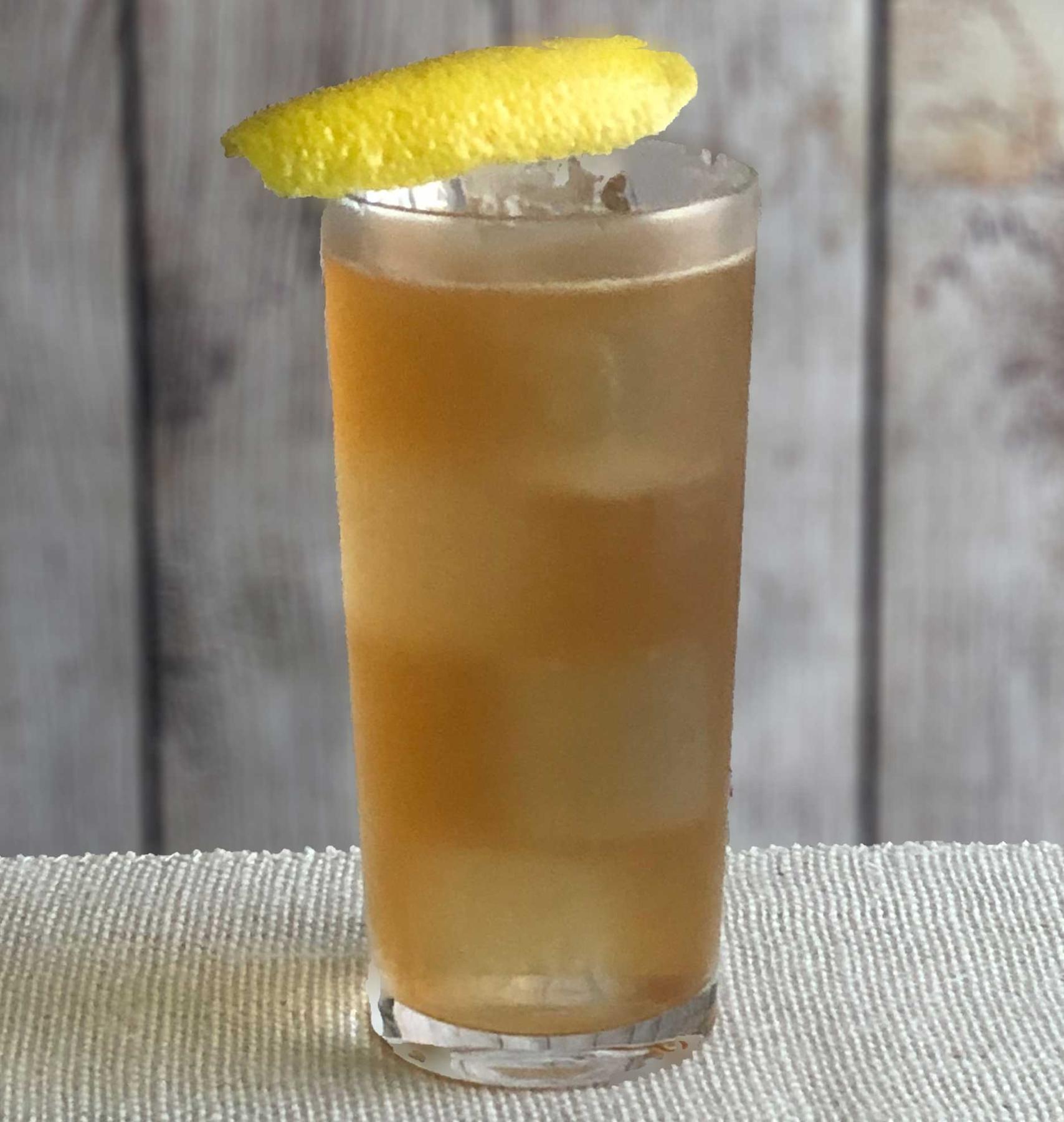 An example of the Service Station Sling, the mixed drink (drink) featuring soda water, blended scotch whisky, Mattei Cap Corse Rouge Quinquina, simple syrup, lemon juice, and lemon twist; photo by Lee Edwards