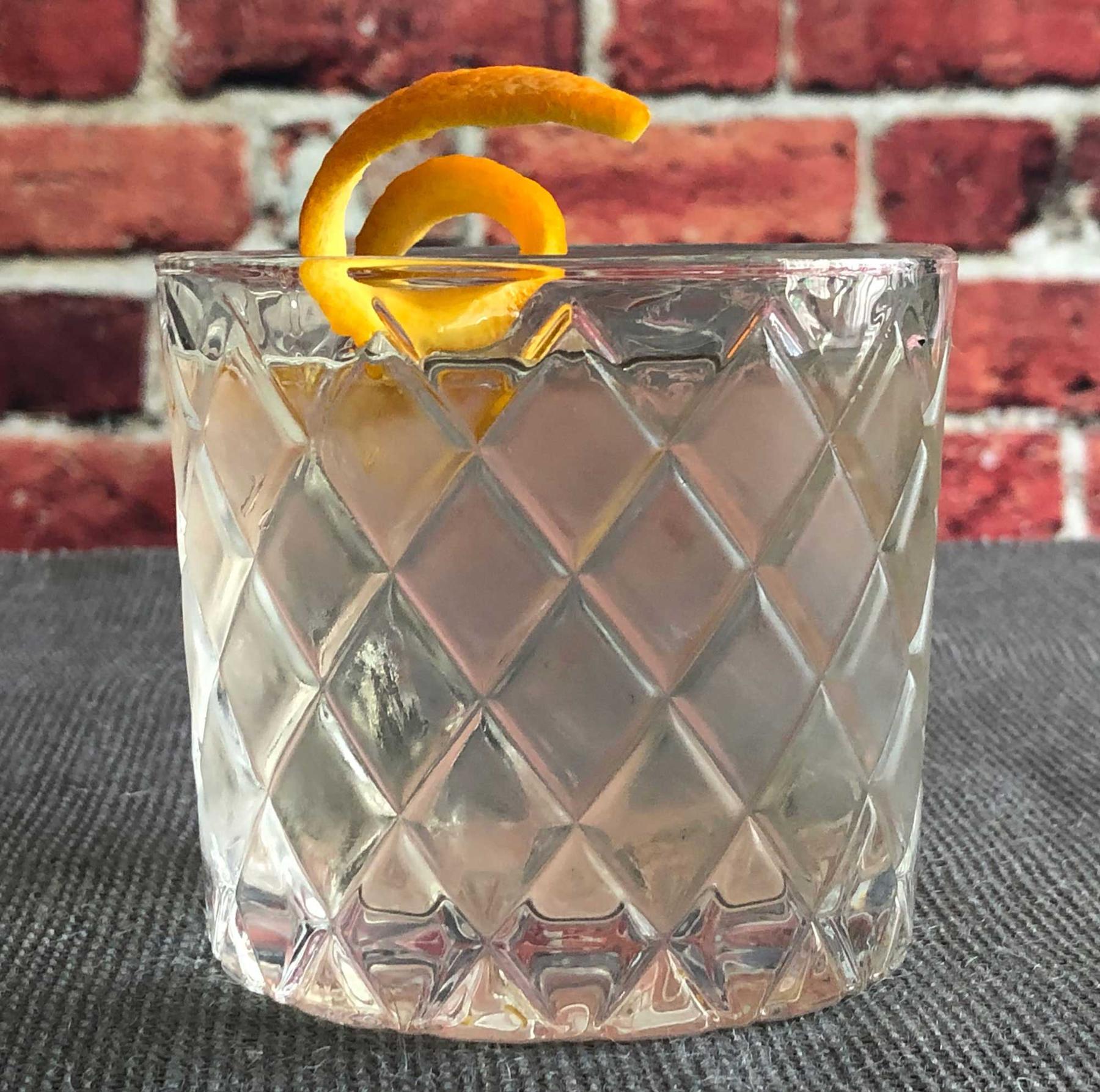 An example of the Pale Horse, the mixed drink (drink), by Brett Bassett, Little Rock, Arkansas, featuring Hayman’s London Dry Gin, Salers Gentian Apéritif, maraschino liqueur, Dolin Dry Vermouth de Chambéry, orange bitters, and orange twist; photo by Lee Edwards