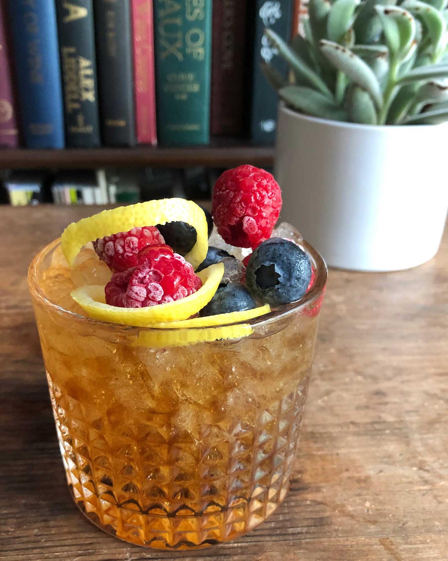 An example of the Conductor’s Cup, the mixed drink (drink) featuring Bonal Gentiane-Quina, sparkling wine, lemon twist, and berry; photo by Lee Edwards