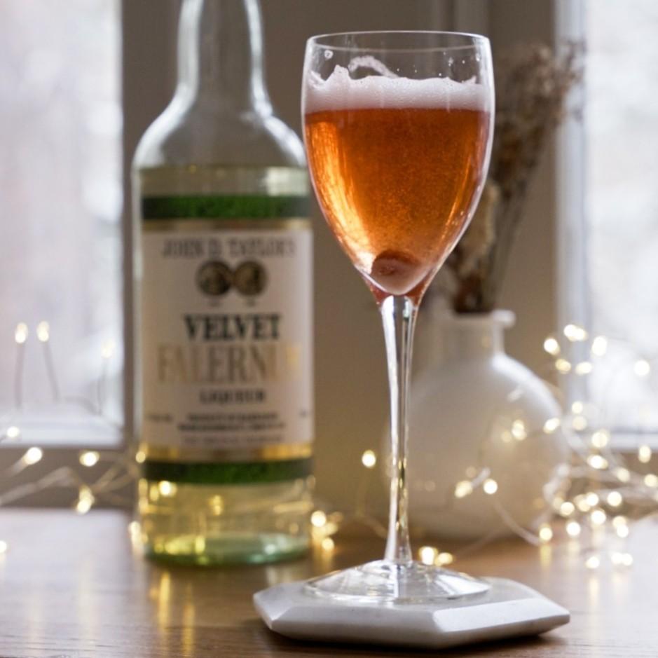 An example of the True Velvet, the mixed drink (drink) featuring sparkling wine, John D. Taylor’s Velvet Falernum, Angostura bitters, and lump of sugar; photo by Madison Young