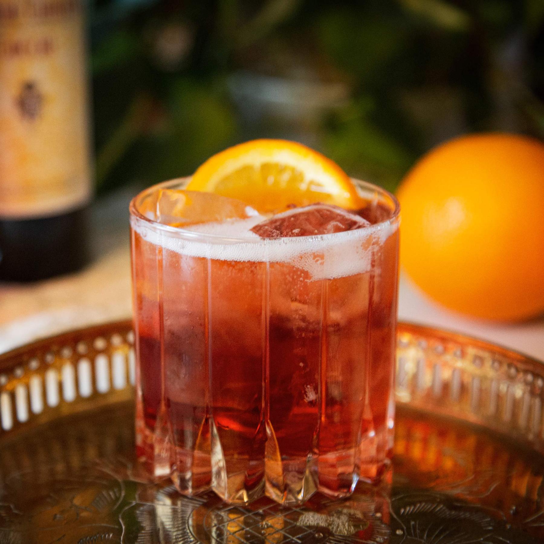 An example of the Appennini Spritz, the mixed drink (drink), Adapted from Adam Bernbach, featuring sparkling wine, Cocchi Barolo Chinato, Aperitivo Mazzura, and orange wheel; photo by Megan Heinowski