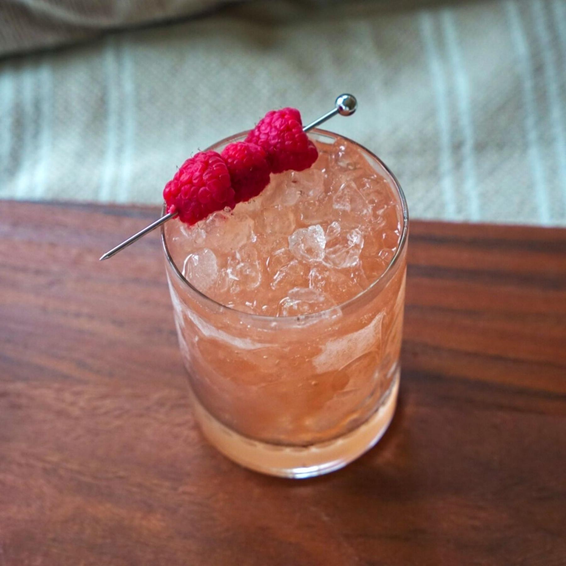 An example of the Knickerbocker, the mixed drink (drink), by Jerry Thomas (modified), featuring The Scarlet Ibis Trinidad Rum, lime juice, raspberry syrup, orange, and berry; photo by Madison Young