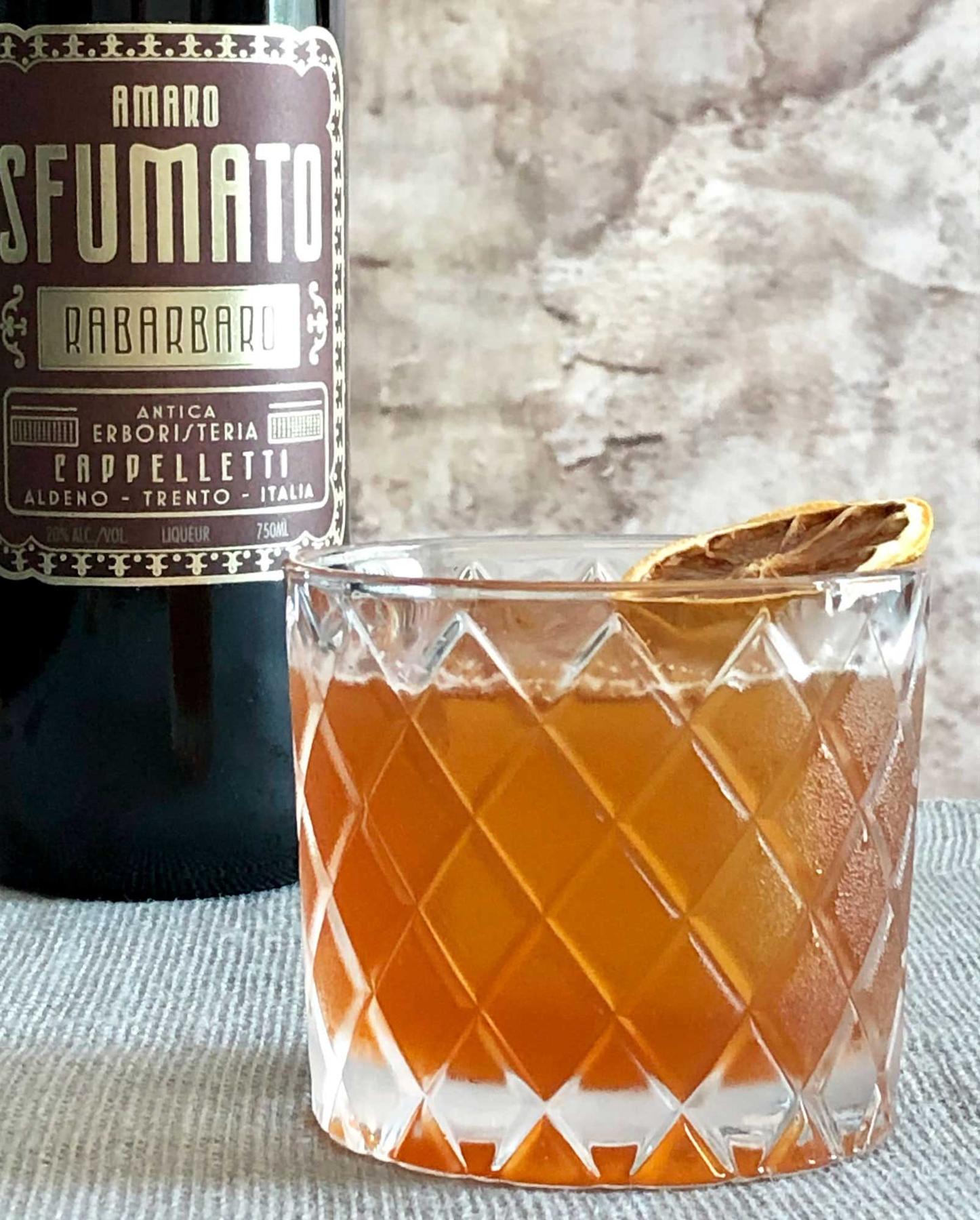 An example of the Welcome, Ghosts, the mixed drink (drink), by Nic Christiansen, Louisville, KY, featuring Copper & Kings Immature Brandy, Amaro Sfumato Rabarbaro, lemon juice, honey syrup, Angostura bitters, Bittermens Xocolatl Mole Bitters, and lemon twist; photo by Lee Edwards