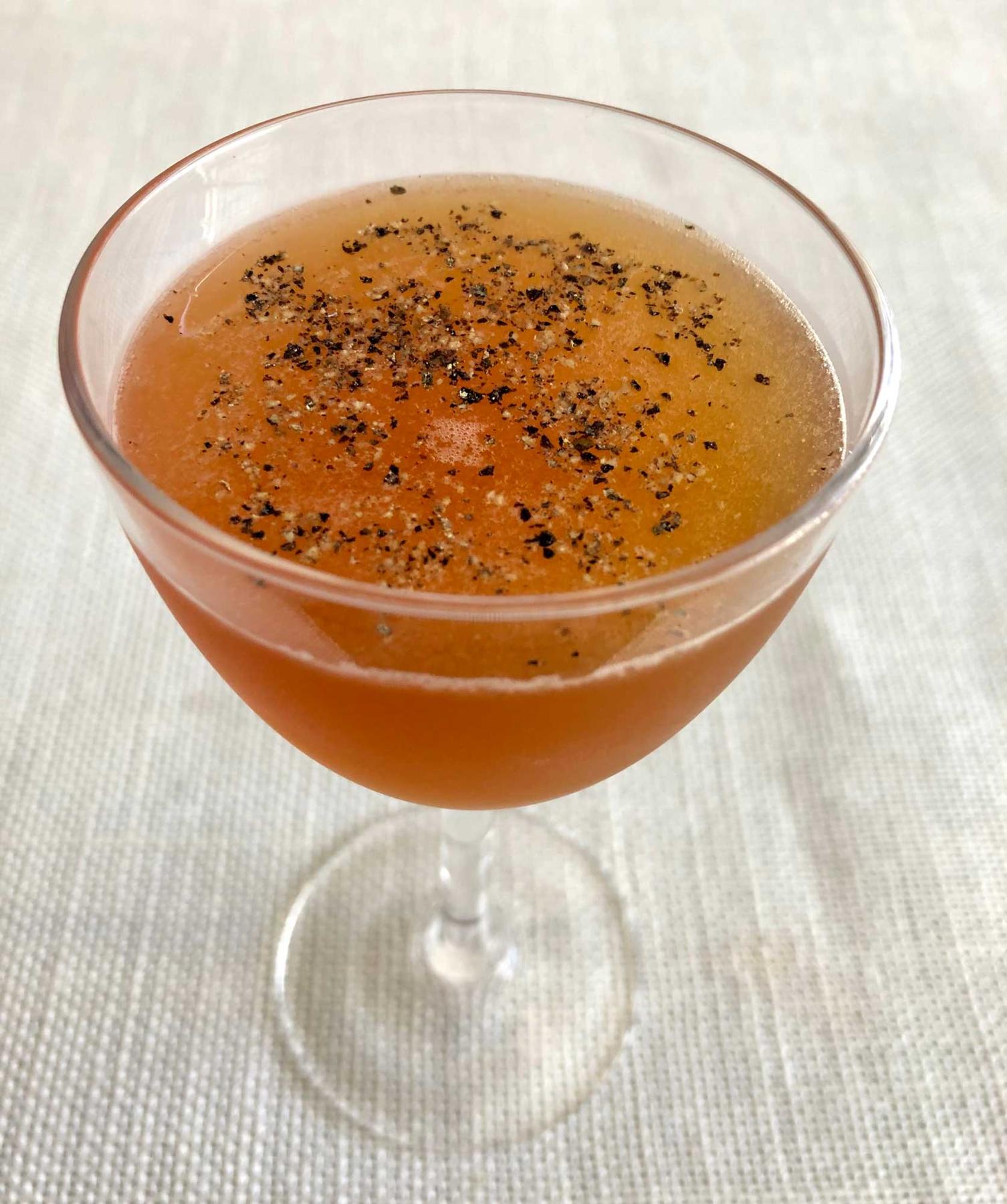 An example of the Tellicherry Cruiser, the mixed drink (drink), variation of the Philomel from the Savoy Cocktail Book, featuring Matifoc Rancio Sec, orange juice, Smith & Cross Traditional Jamaica Rum, Bonal Gentiane-Quina, Byrrh Grand Quinquina, and peppercorn; photo by Lee Edwards