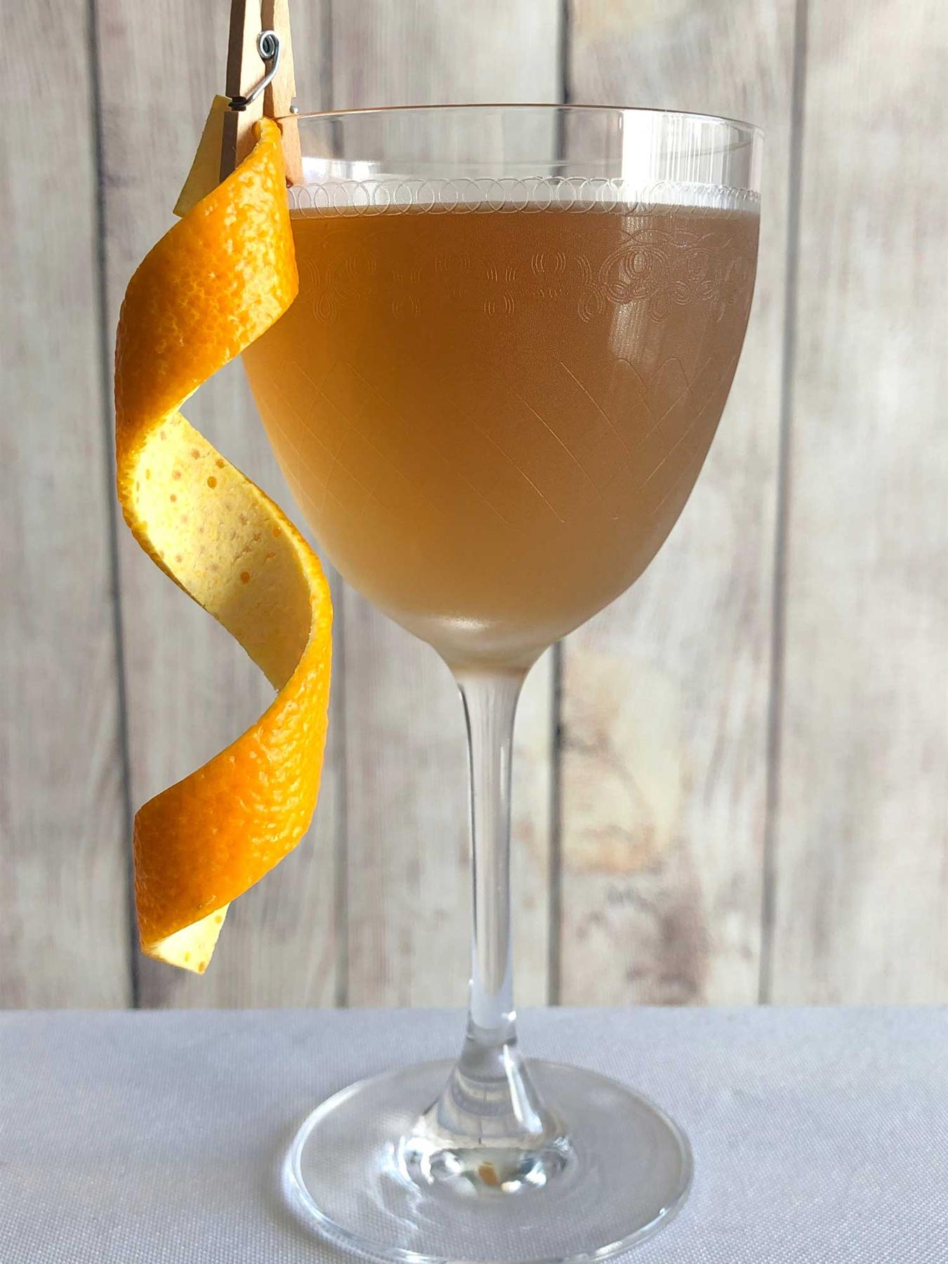 An example of the Future Perfect, the mixed drink (drink) featuring Hayman’s Old Tom Gin, Dolin Dry Vermouth de Chambéry, Dolin Rouge Vermouth de Chambéry, and orange twist; photo by Lee Edwards