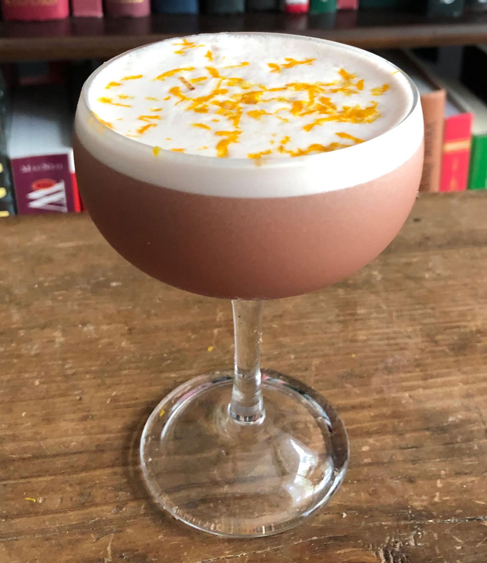 An example of the Damson Dove, the mixed drink (drink), by Dovetail, New York City, featuring Averell Damson Plum Gin Liqueur, egg white, lemon juice, simple syrup, and orange twist; photo by Lee Edwards