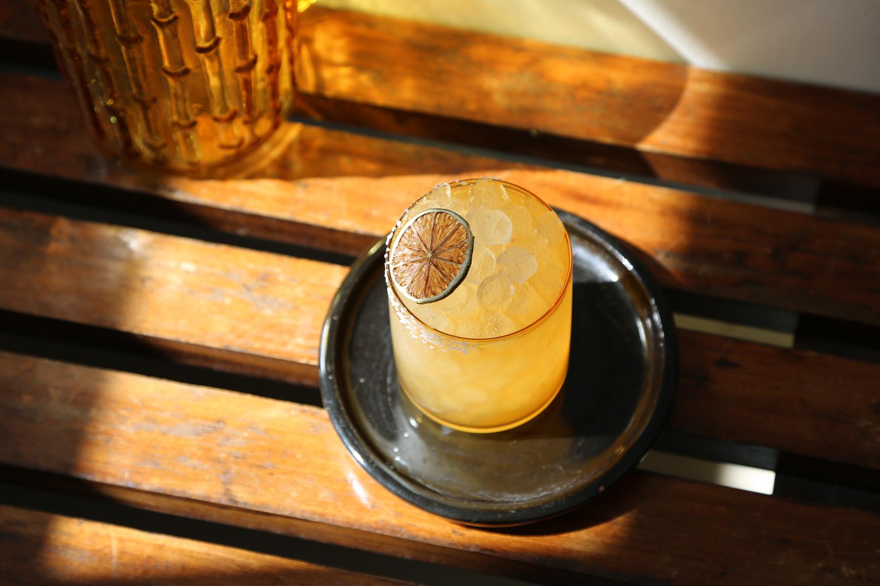 An example of the Quincessential Margarita, the mixed drink (drink) featuring reposado tequila, Rothman & Winter Orchard Quince Liqueur, lemon juice, agave syrup, St. Elizabeth Allspice Dram, and lime wheel; photo by Megan Heinowski