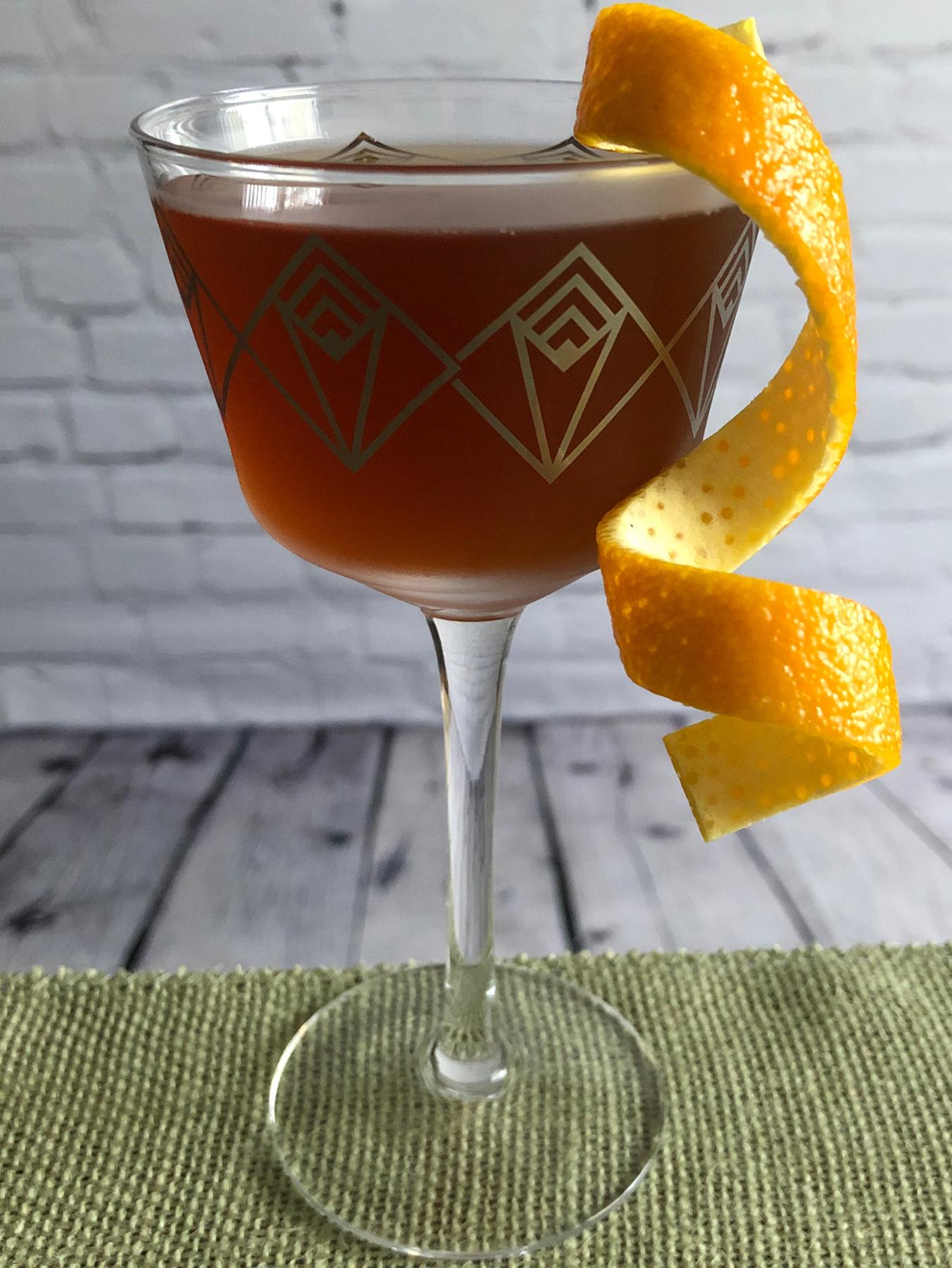 An example of the The Hammer, the mixed drink (drink) featuring Mattei Cap Corse Rouge Quinquina, bourbon whiskey, KRONAN Swedish Punsch, orange bitters, and orange twist; photo by Lee Edwards