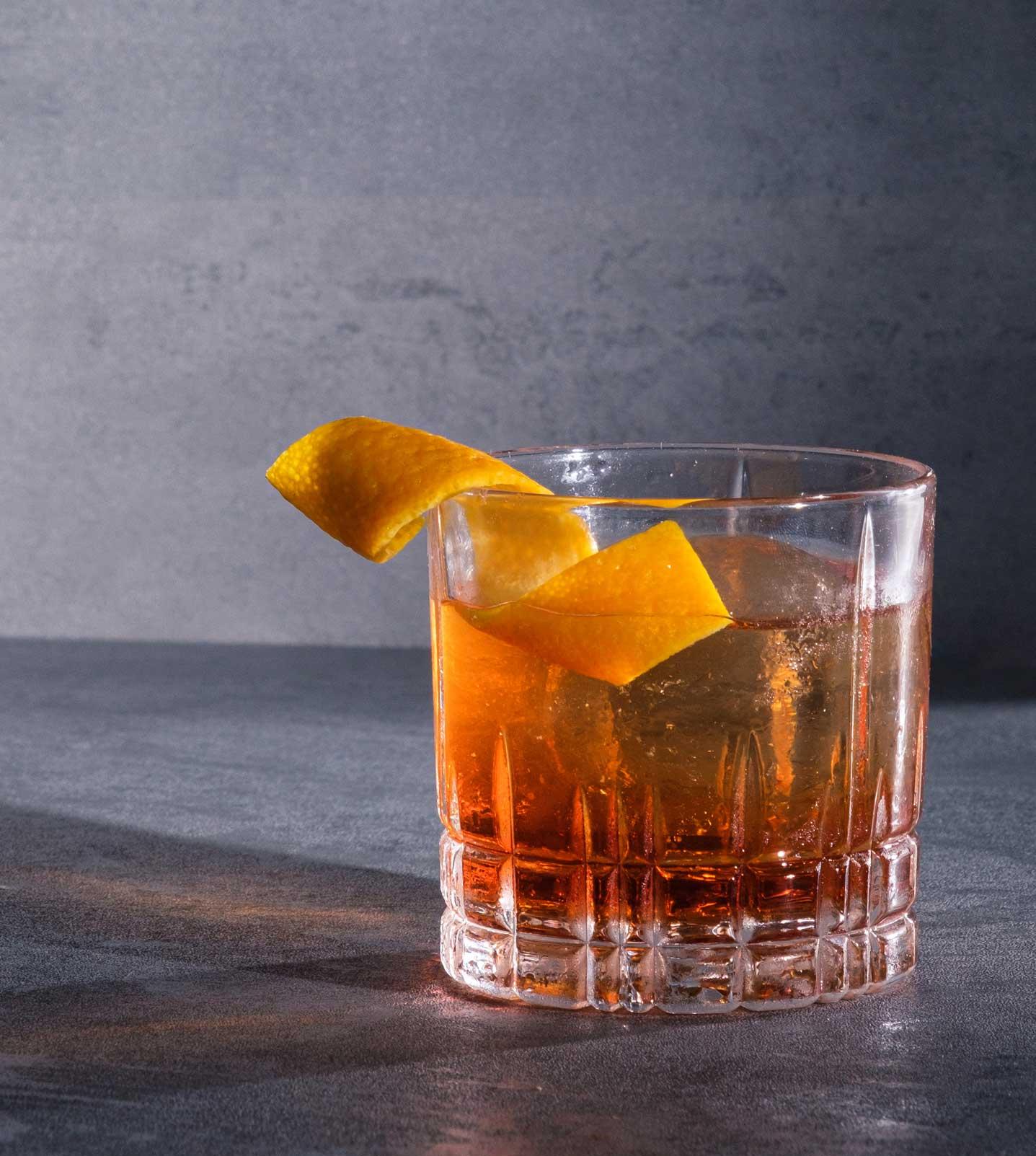 An example of the Haus Negroni, the mixed drink (drink) featuring Hayman’s Royal Dock Navy Strength Gin, Aperitivo Cappelletti, Dolin Rouge Vermouth de Chambéry, and orange twist; photo by Miranda Hodge