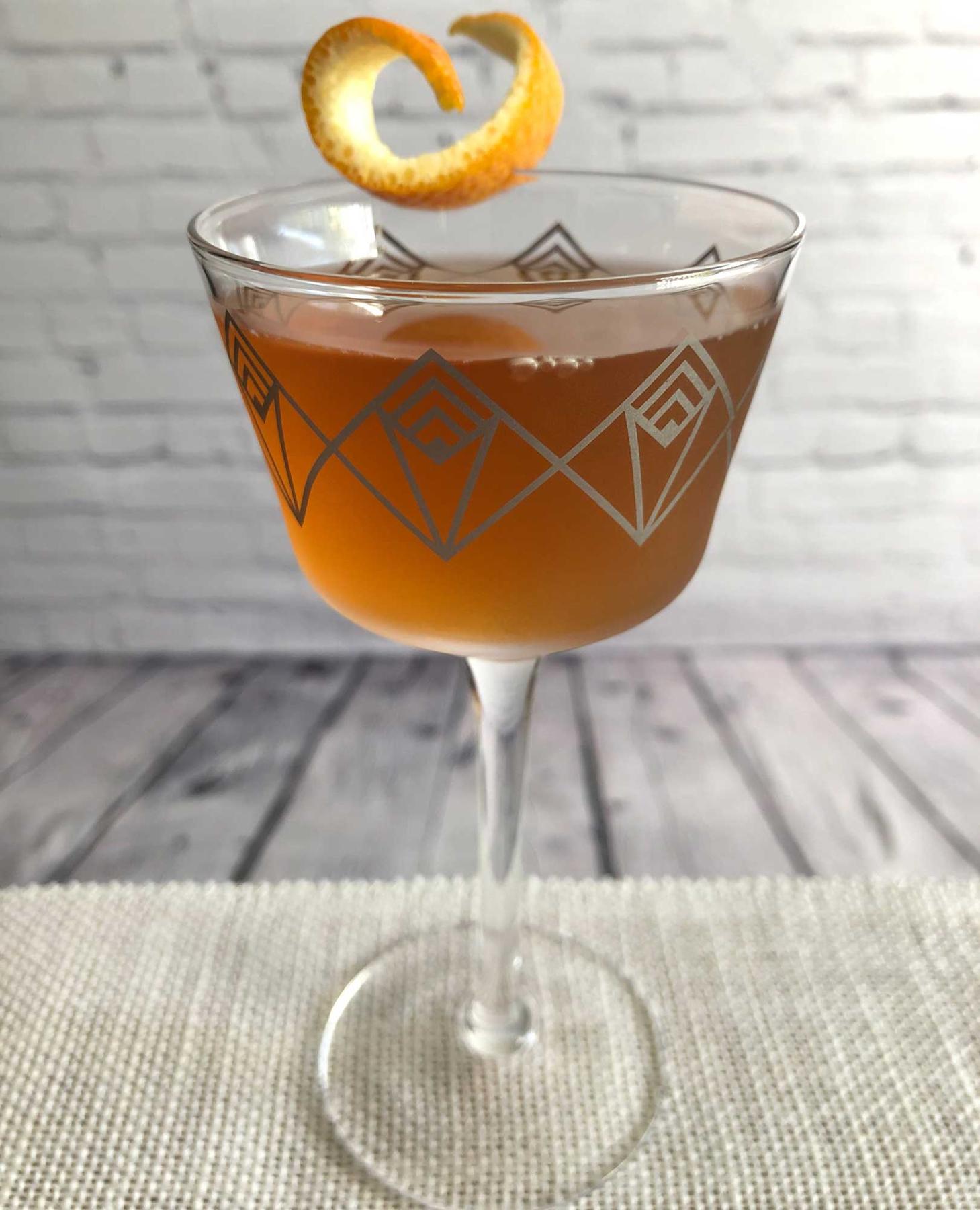 An example of the Autumn Sunset, the mixed drink (drink), by “Sanctuaria: The Dive Bar of Cocktail Bars”, featuring bourbon whiskey, Cocchi Vermouth di Torino ‘Storico’, Dolin Dry Vermouth de Chambéry, St. Elizabeth Allspice Dram, Bénédictine, and orange twist; photo by Lee Edwards