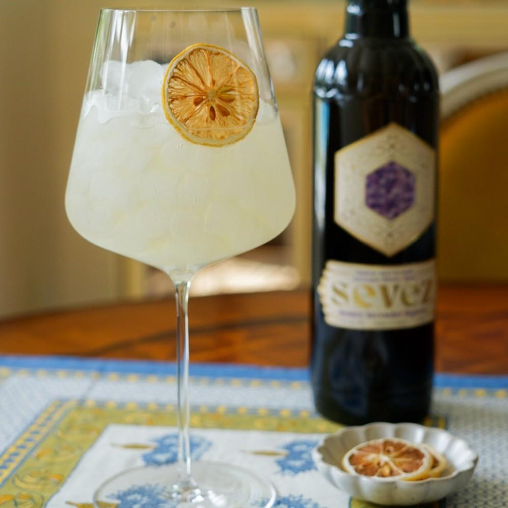 An example of the Sevez Spritz, the mixed drink (drink) featuring sparkling wine, Sevez Honey Lavender, and lemon twist