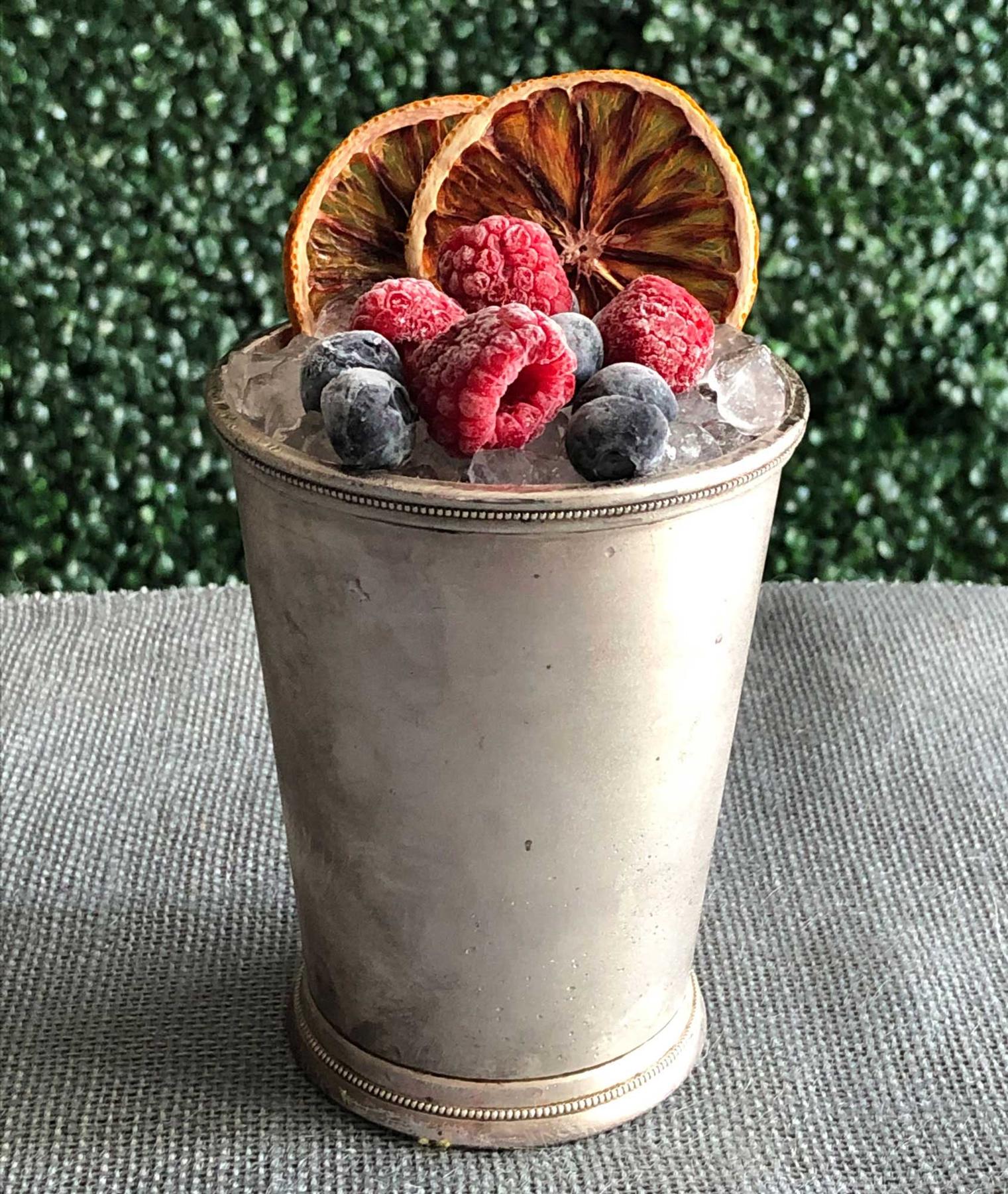 An example of the Bonal Cobbler, the mixed drink (drink), by Kirk Estopinal, Bellocq, New Orleans, featuring Bonal Gentiane-Quina, orange wheel, sugar, grapefruit twists, and berry; photo by Lee Edwards