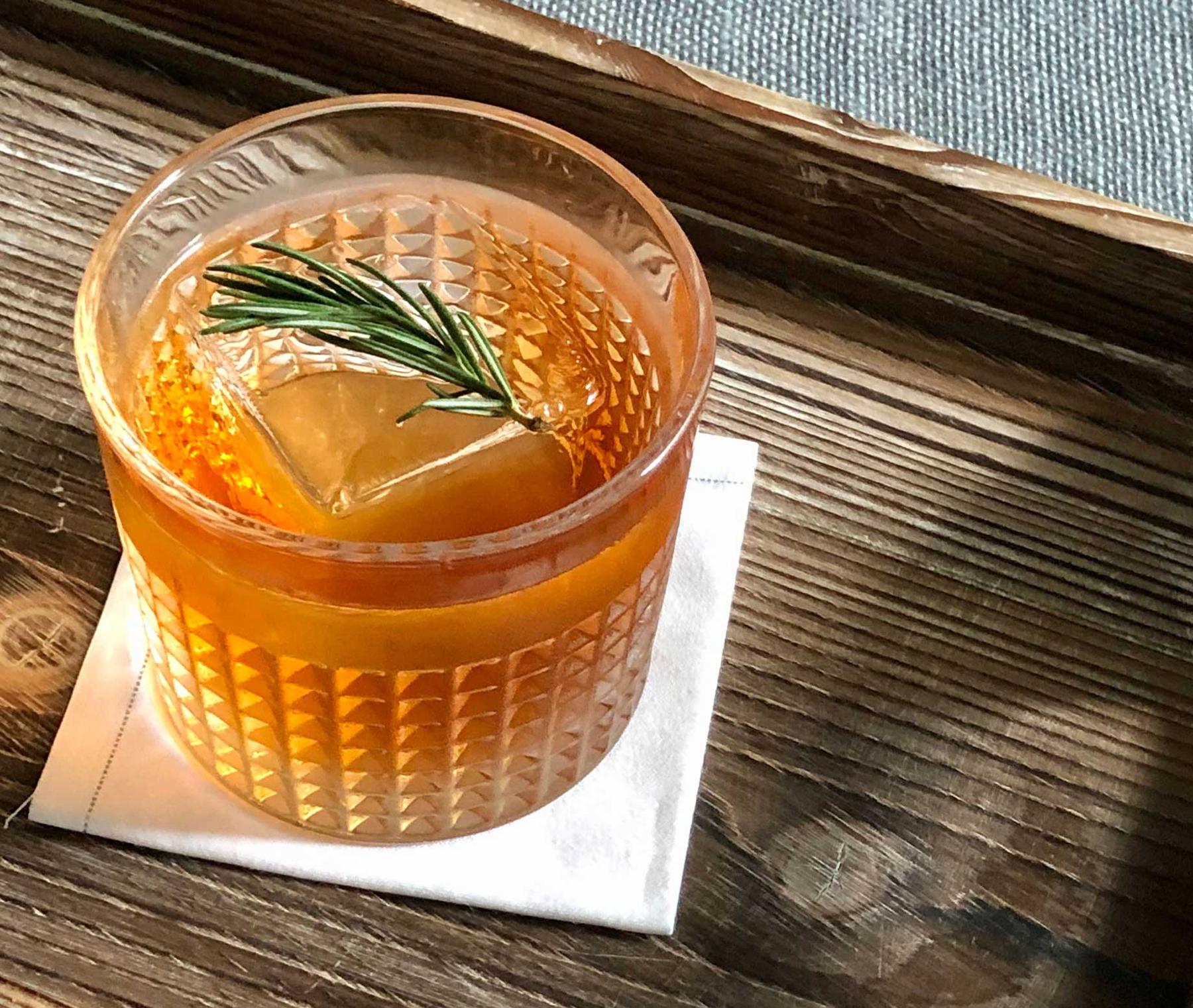An example of the Schleswig Limbo, the mixed drink (drink), adapted from a drink by Luiggi Uzcategui, Big Orange, Little Rock, Arkansas, featuring Purkhart Pear Williams Eau-de-Vie, The Scarlet Ibis Trinidad Rum, Rothman & Winter Orchard Cherry Liqueur, Aperitivo Cappelletti, and sprig of rosemary; photo by Lee Edwards