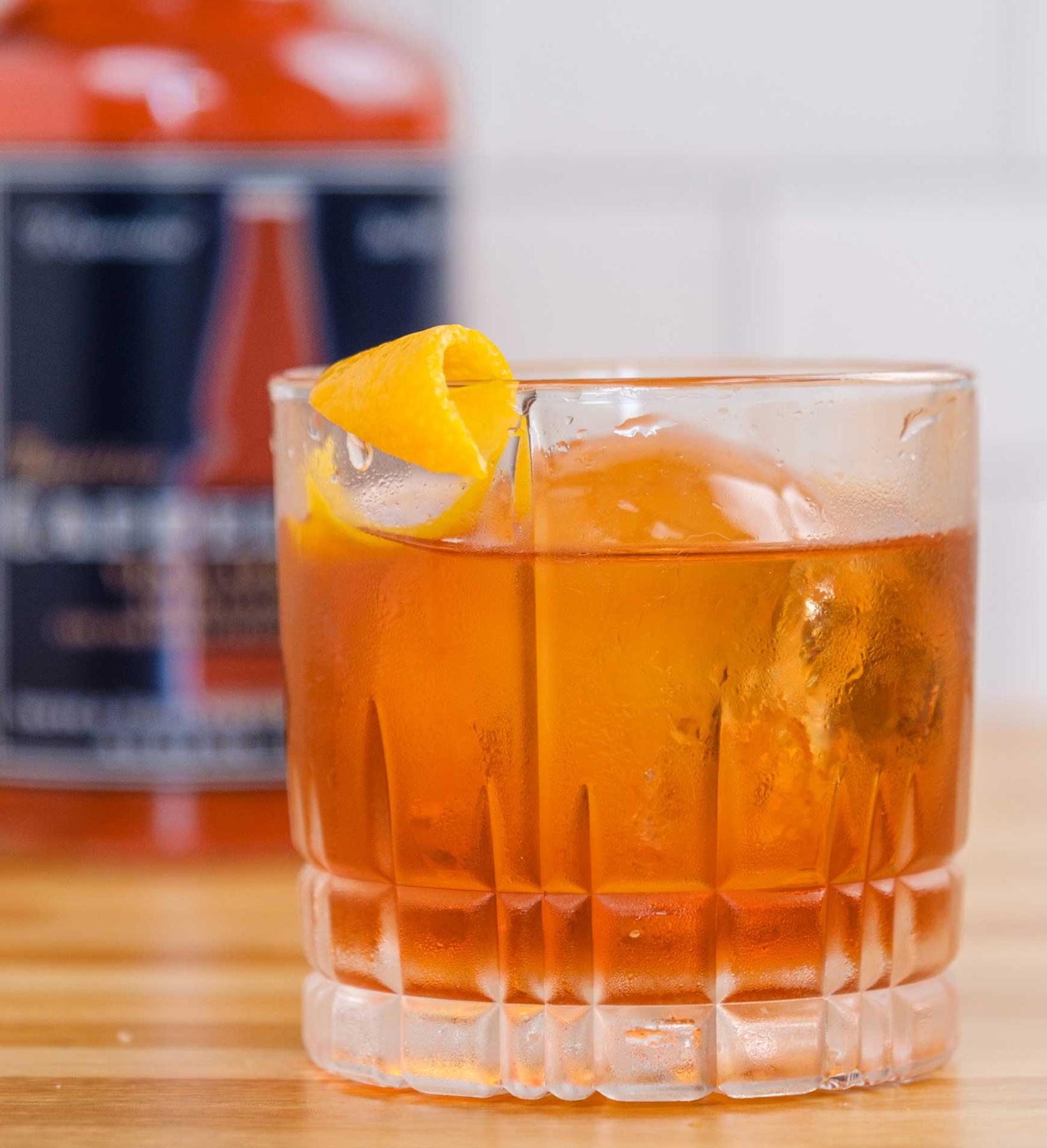 An example of the Boulevardier, the mixed drink (drink) featuring bourbon whiskey, Aperitivo Cappelletti, Dolin Rouge Vermouth de Chambéry, and orange twist; photo by Miranda Hodge