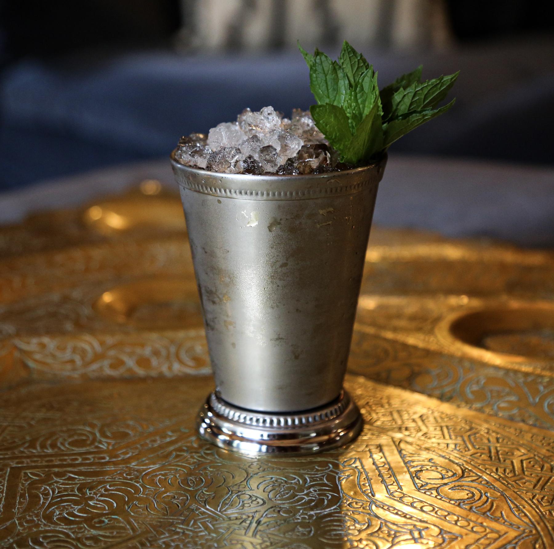 An example of the Brandy Mist, the mixed drink (drink), by Charles Baker (modified), featuring cognac, Rothman & Winter Orchard Peach Liqueur, simple syrup, aromatic bitters, and sprig of mint; photo by Madison Young
