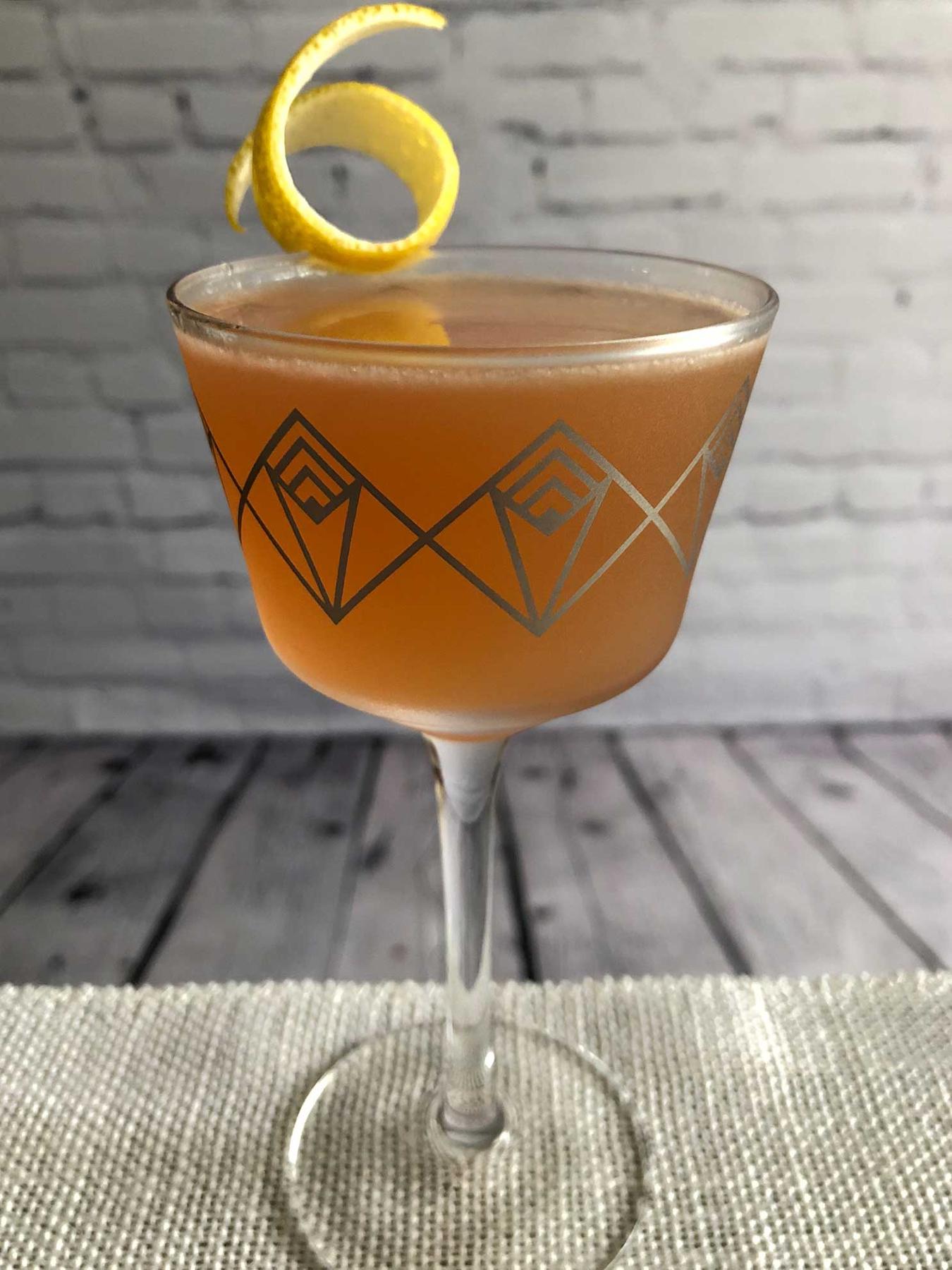 An example of the Jazz Flute, the mixed drink (drink), by riff on Gilchrist, PDT book, featuring scotch whisky, Purkhart Pear Williams Eau-de-Vie, pink grapefruit juice, Cardamaro Vino Amaro, simple syrup, grapefruit bitters, and lemon twist; photo by Lee Edwards