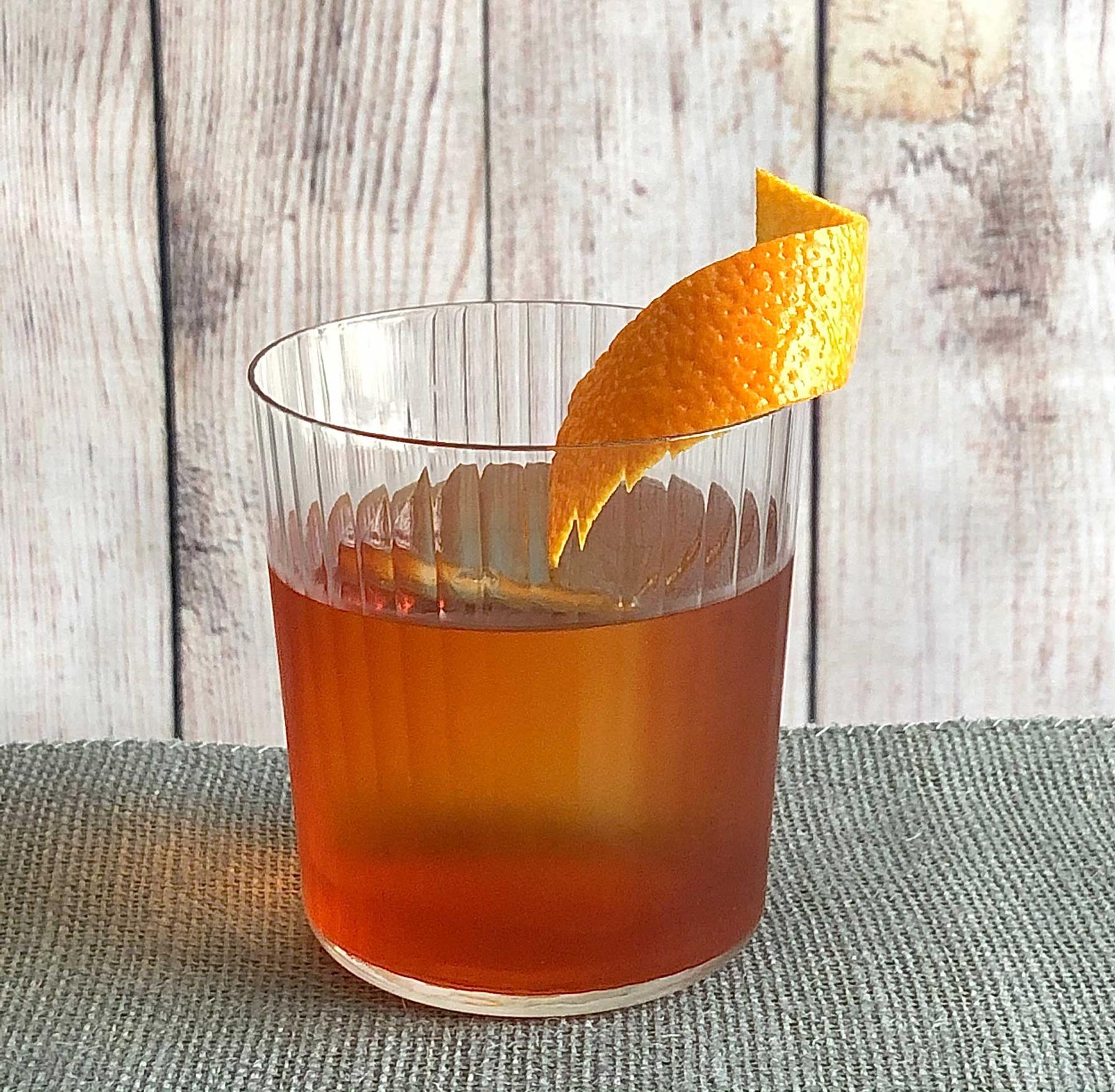 An example of the Boulevardier, the mixed drink (drink) featuring Mattei Cap Corse Rouge Quinquina, Aperitivo Cappelletti, rye whiskey, and orange twist; photo by Lee Edwards