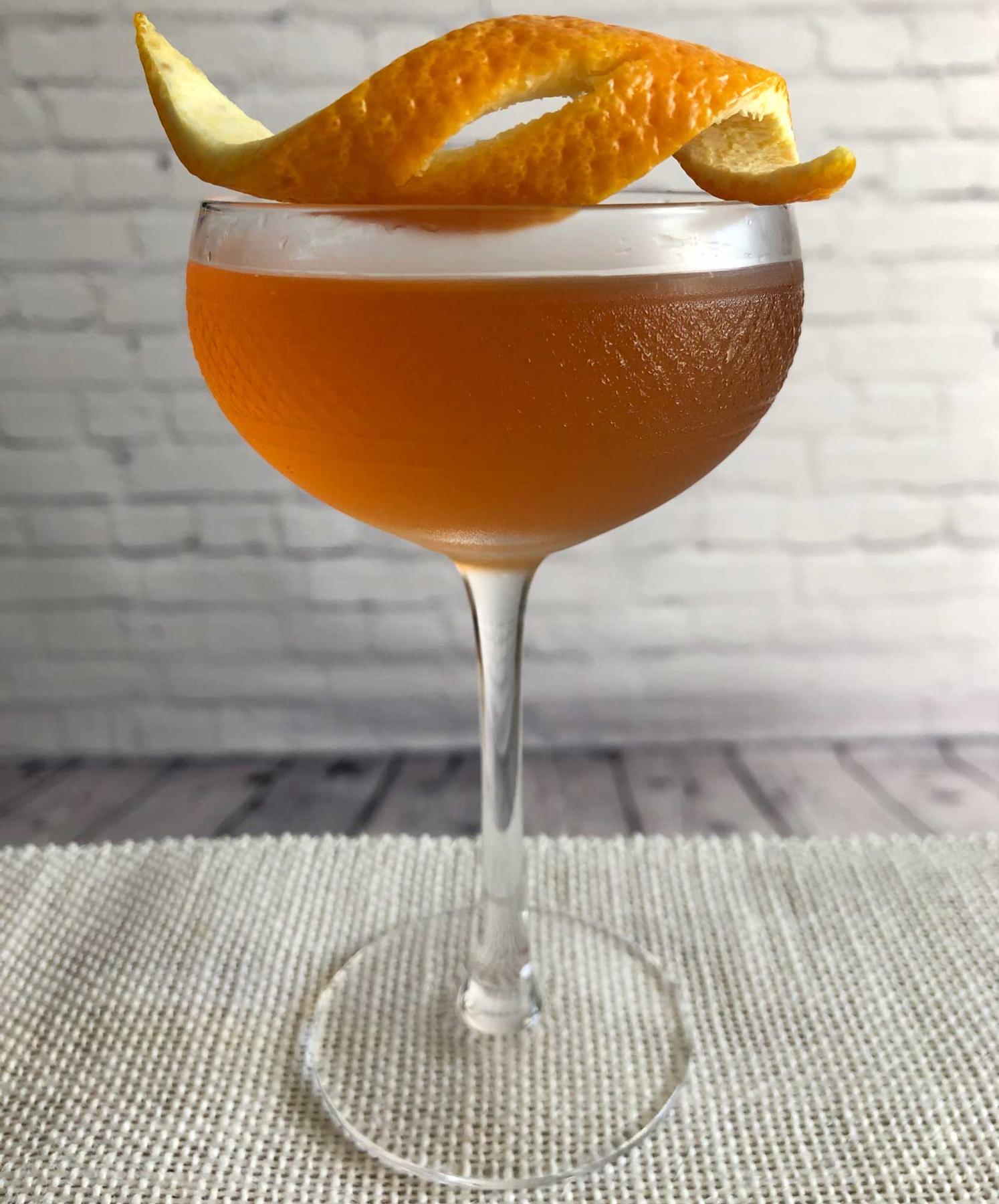 An example of the Boomerang Cocktail, the mixed drink (drink), by Savoy Cocktail Book, featuring KRONAN Swedish Punsch, rye whiskey, Dolin Dry Vermouth de Chambéry, lemon juice, Angostura bitters, orange bitters, and lemon twist; photo by Lee Edwards