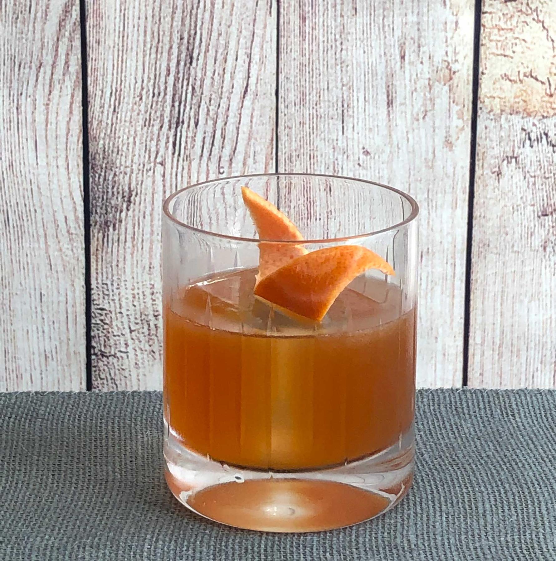 An example of the Fair Isle Cocktail, the mixed drink (drink), by Kathy Casey, Seattle, WA, featuring Cocchi Barolo Chinato, grapefruit juice, scotch whisky, grapefruit bitters, and grapefruit twist; photo by Lee Edwards
