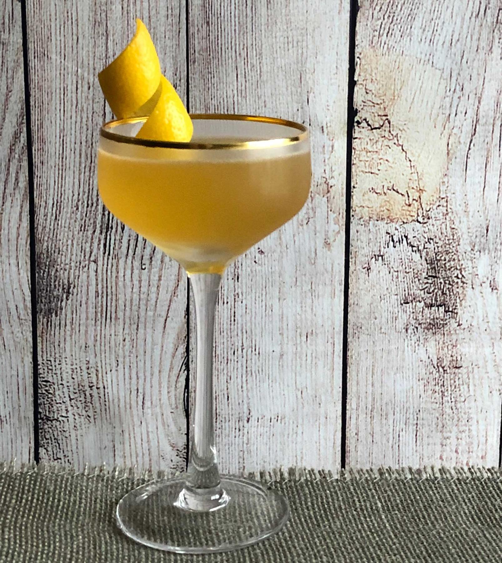 An example of the Havana Cocktail, the mixed drink (drink) featuring Blume Marillen Apricot Eau-de-Vie, KRONAN Swedish Punsch, Hayman’s Royal Dock Navy Strength Gin, lemon juice, simple syrup, and lemon twist; photo by Lee Edwards