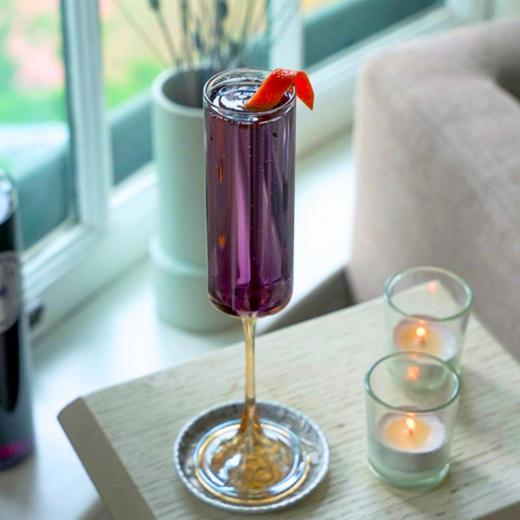 An example of the Violette Royale, the mixed drink (drink) featuring sparkling wine, Rothman & Winter Crème de Violette, and grapefruit twist; photo by Madison Young